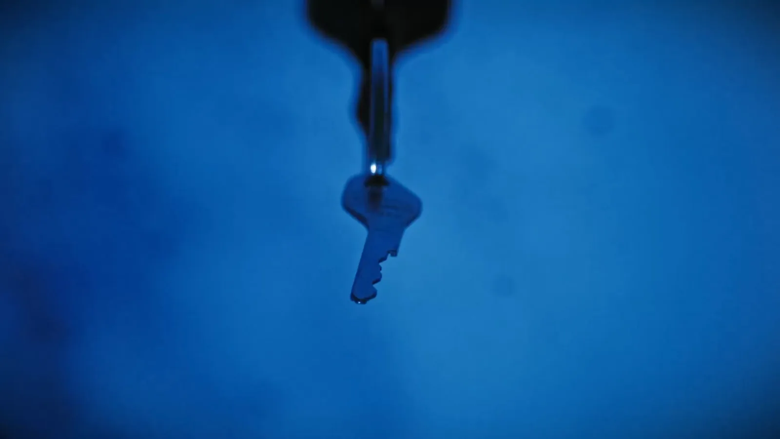 A single key dangling in blue light in Asylum