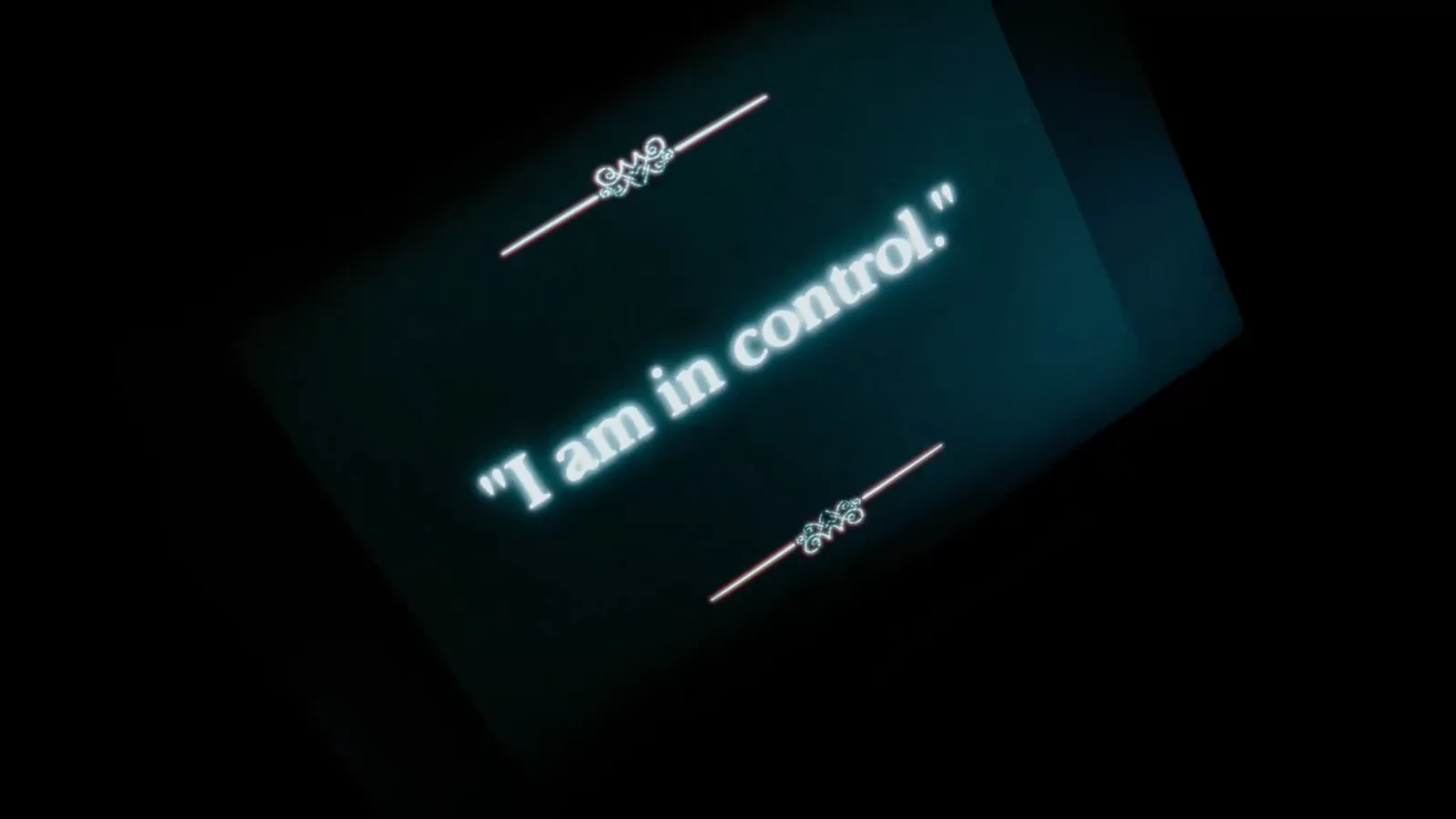 A screen in the dark reading “I am in control” inside Asylum