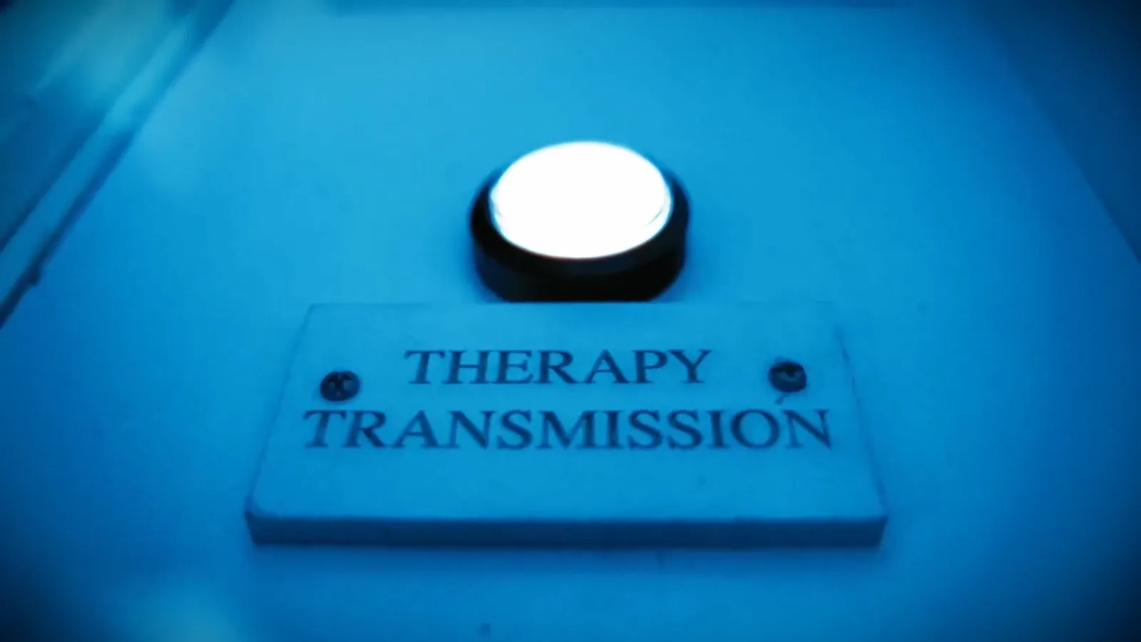 A glowing button labelled Therapy Transmission in the Asylum escape room